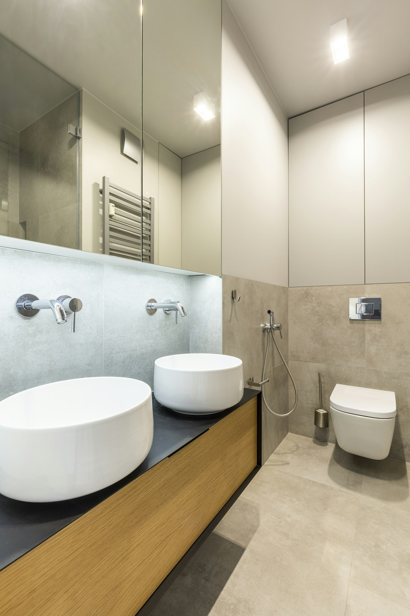 Mirror above washbasin in beige elegant bathroom interior with l